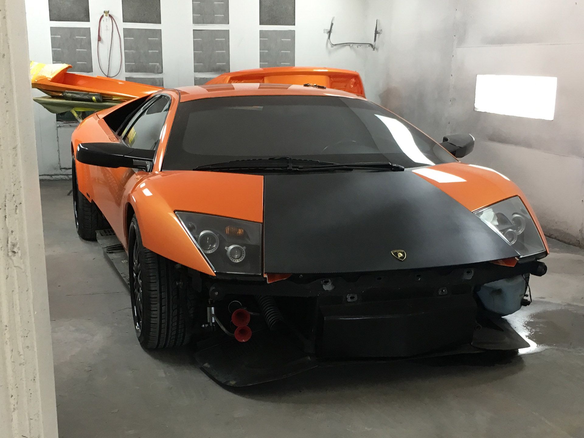 Front view of orange Lambourghini with hood primed